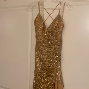 Gold sequined, Thigh high slit, thin straps lead to crisscross tie back.